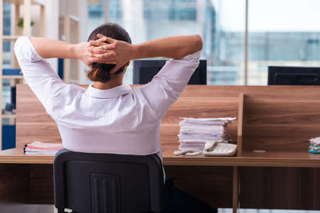 Young male employee and too many work in the officeの写真素材