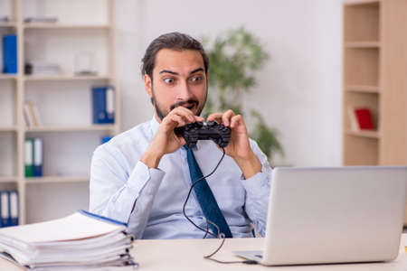 Young male employee playing joystick games during his breakの写真素材