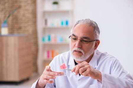 Old male chemist testing soap in the lab