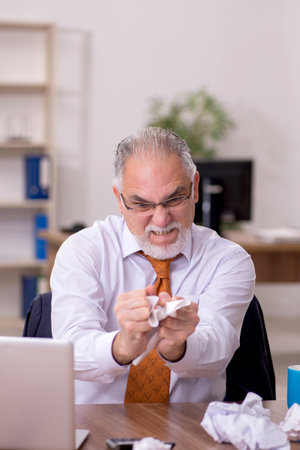 Old male employee in paper recycling conceptの写真素材