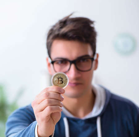 Young man mining bitcoins at homeの写真素材