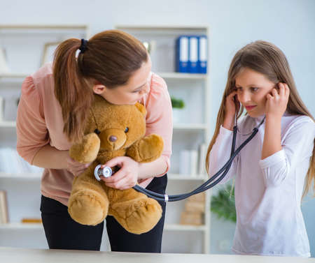 Young girl playing doctor in early development conceptの写真素材