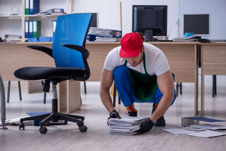 Young male contractor cleaning the officeの写真素材