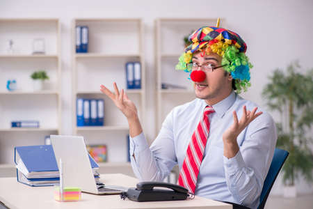 Funny employee clown working in the officeの写真素材