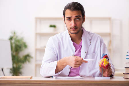 Young male doctor student cardiologist sitting in the classroomの写真素材