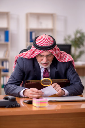Aged arab businessman employee sitting at workplaceの写真素材