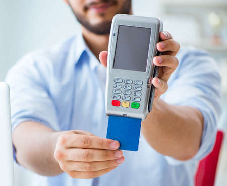 Man processing credit card transaction with POS terminalの写真素材