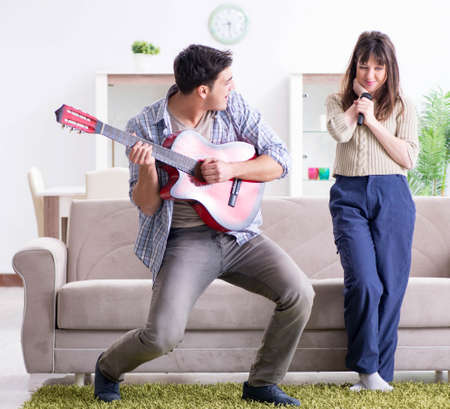 Young family singing and playing music at homeの写真素材