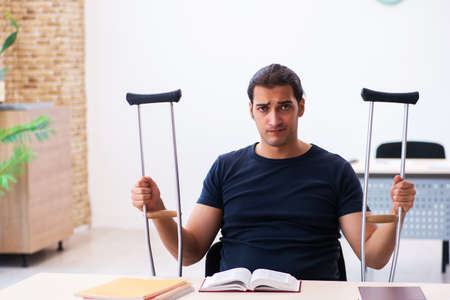 Young male student after accident preparing for exams