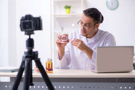 Young male doctor dentist recording video for his blogの写真素材