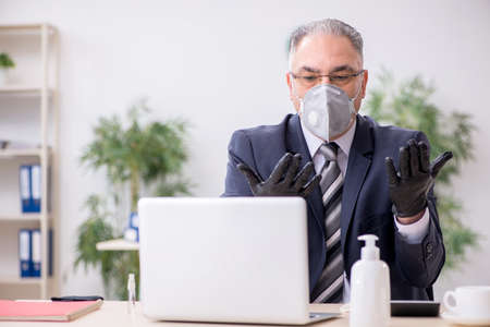 Old male boss employee working during pandemicの写真素材