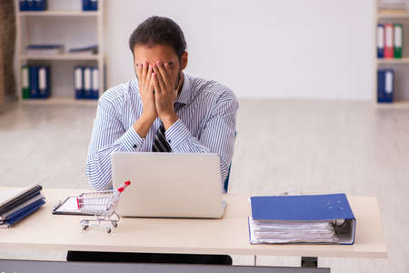 Young male employee in ecommerce conceptの写真素材