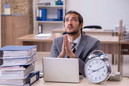 Young male employee in time management conceptの写真素材