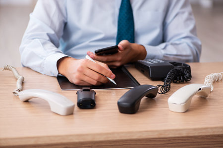 Young male call center operator working at his deskの写真素材