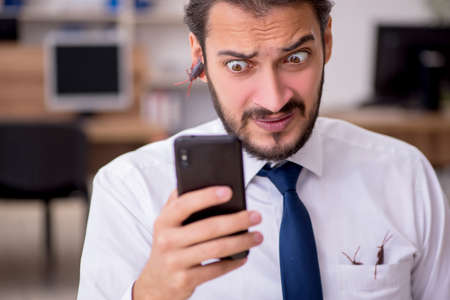 Young male employee and too many cockroaches in the officeの写真素材