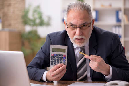 Aged male bookkeeper sitting at workplaceの写真素材