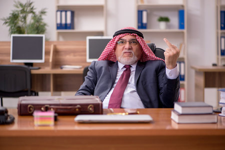 Aged arab businessman employee sitting at workplaceの写真素材