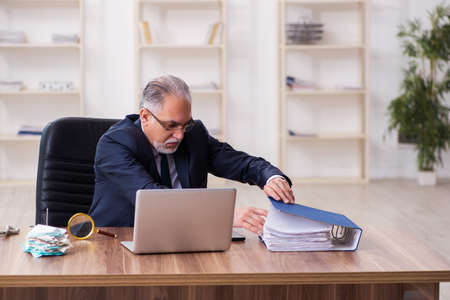 Old businessman employee in budget planning conceptの写真素材