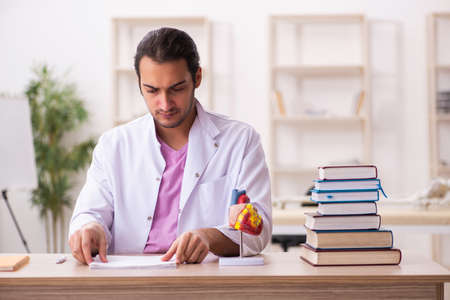 Young male doctor student cardiologist sitting in the classroomの写真素材