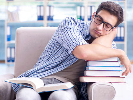 Student reading books and preparing for exams in libraryの写真素材