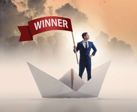 Businessman riding paper boat ship in winning conceptの写真素材