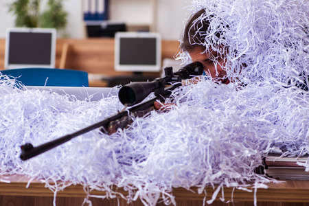Young male employee and a lot of cut papers in the office