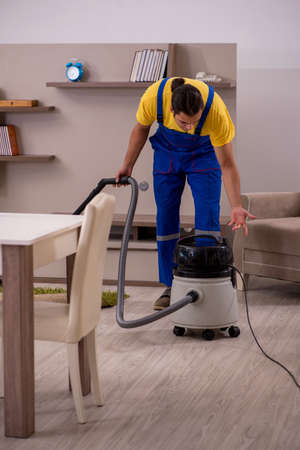 Young male contractor cleaning the houseの写真素材