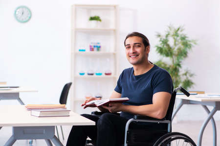 Young male student in wheel-chair preparing for examsの写真素材