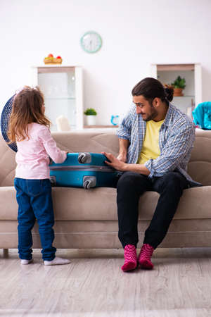 Young man and his small daughter preparing for the tripの写真素材