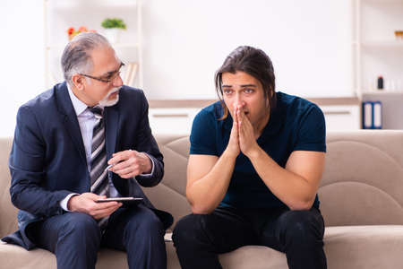 Young man visiting old male psychologistの写真素材