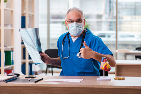 Old male doctor radiologist working in the clinicの写真素材