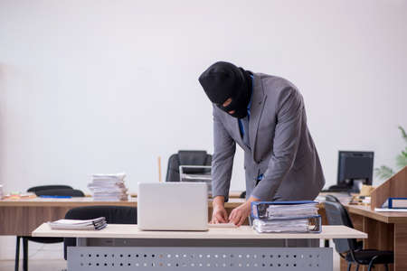 Young male employee in industrial espionage conceptの写真素材