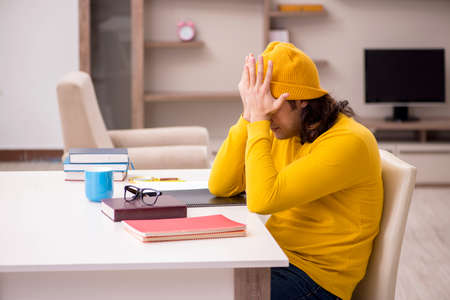 Young male student preparing for exams at home