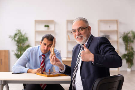 Two businessmen playing chess in the officeの写真素材