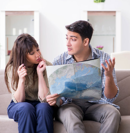 Young family discussing travel plans with mapの写真素材