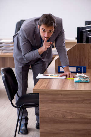 Young male employee in industrial espionage conceptの写真素材