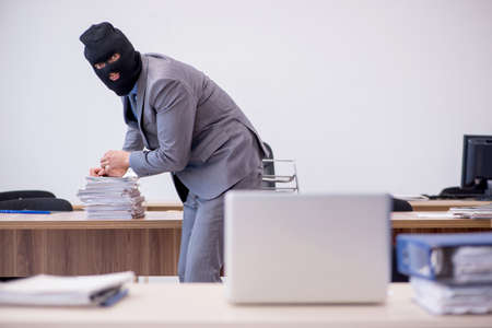 Young male employee in industrial espionage conceptの写真素材