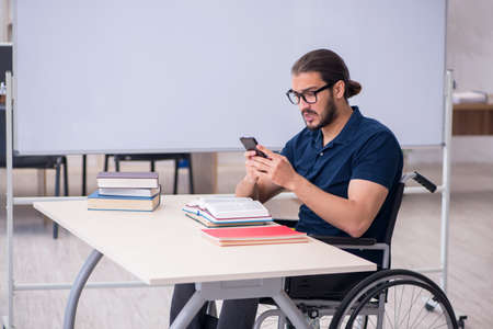Young male handicapped student in the classroomの写真素材