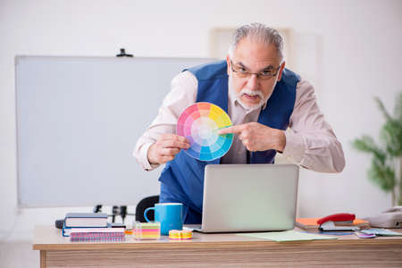 Old male designer working in the officeの写真素材