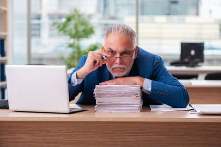 Old male boss employee working in the officeの写真素材