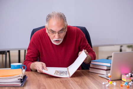 Old teacher physicist in remuneration conceptの写真素材