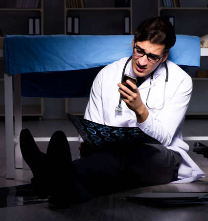 Doctor working night shift in hospital after long hoursの写真素材