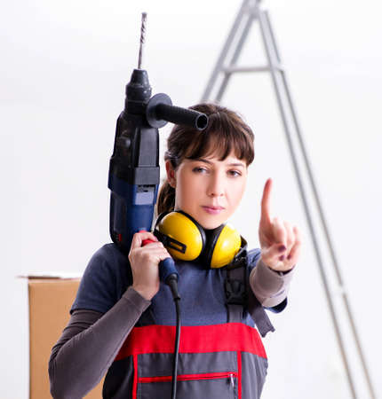 Woman contractor with hand drill at construction siteの写真素材