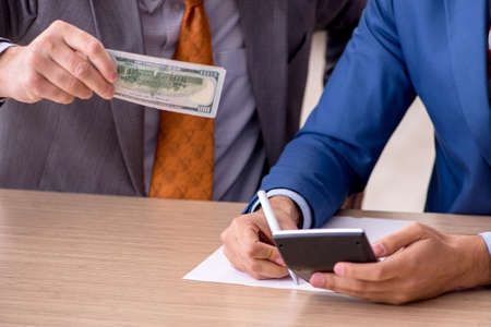 Two male employees in remuneration conceptの写真素材