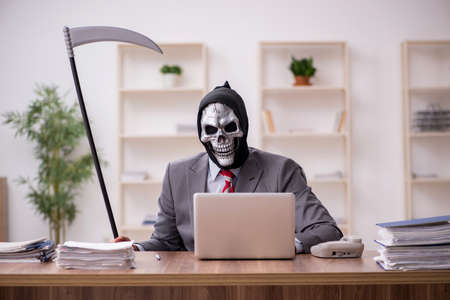 Devil businessman employee sitting at workplaceの写真素材