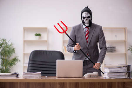 Devil businessman employee sitting at workplace