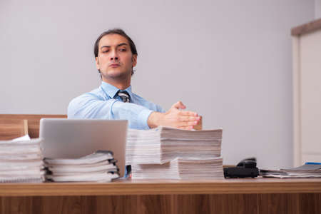 Young male employee unhappy with excessive workの写真素材