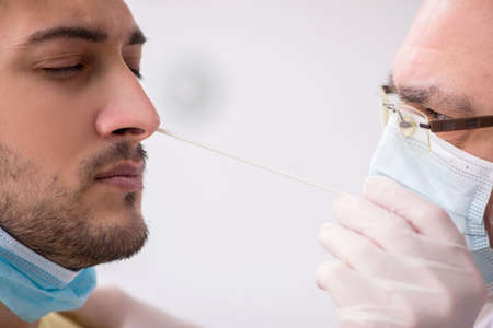 Young male patient visiting old male doctor otorhinolaryngologis