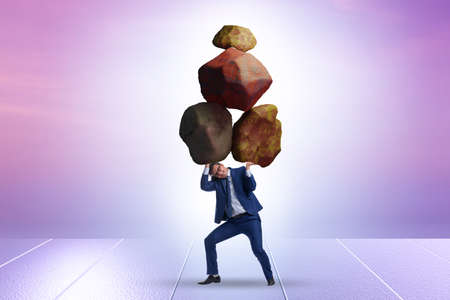 Businessman under burden in business conceptの写真素材