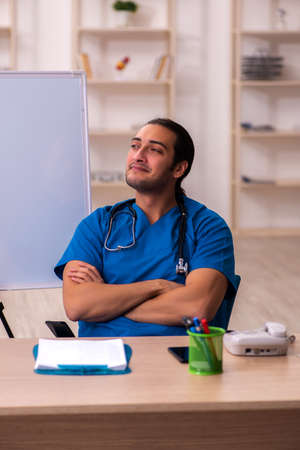 Young male doctor in front of whiteboardの写真素材